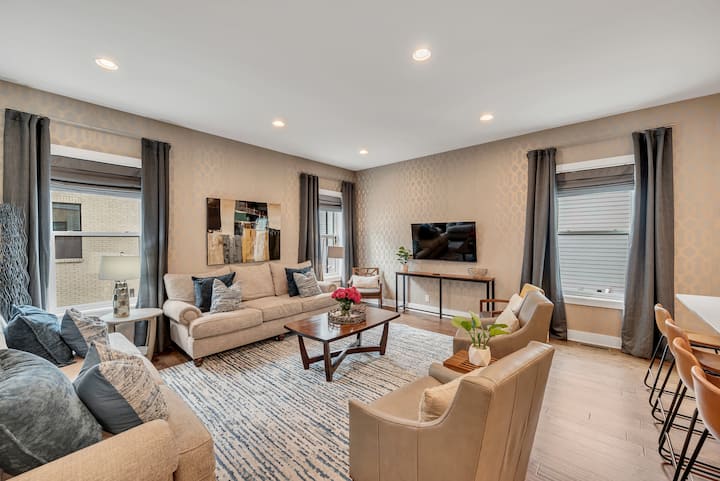 *宽敞的客厅与厨房相通，配备充足的座位、大屏智能电视和遮光窗帘

