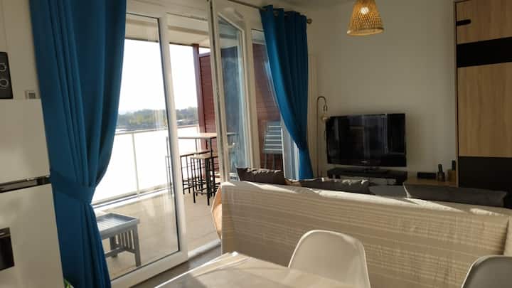Woonkamer met 1 slaapbank, TV en balkon in de buurt. Het is erg helder.