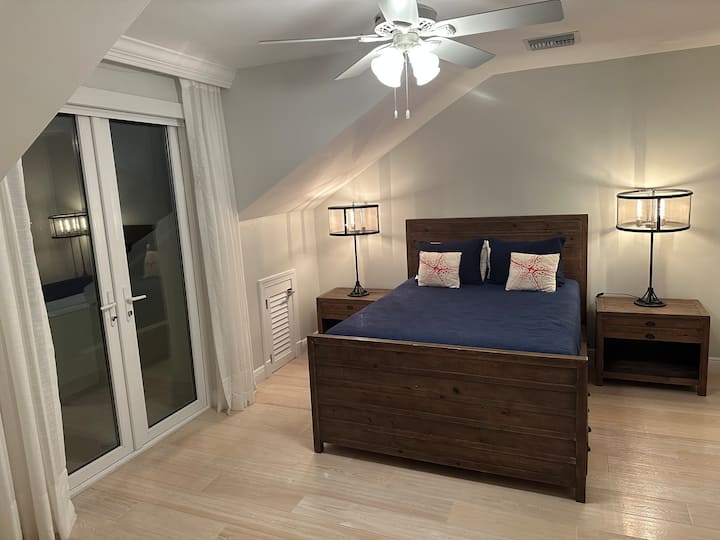 Chumba hiki cha kulala cha ghorofa ya tatu chenye nafasi kubwa kina kitanda cha kifalme na roshani yake inayoangalia bustani iliyo nyuma ya nyumba. Inashiriki bafu  na chumba moja kwa moja kwenye ukumbi.