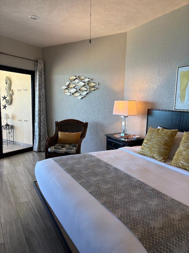 The primary bedroom is perfect for stargazing at night and restful sleep. On cool evenings, slide open the windows for fresh sea breezes.