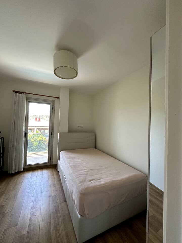 dormitorio con cama individual y una cama supletoria plegable