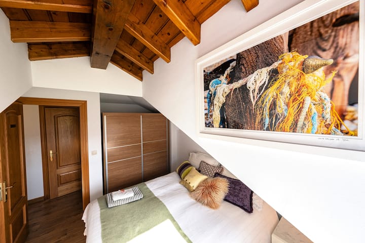 Main bedroom with king sized Tempur bed and pillows, chest of drawers and bedside table plus soft seat/cushion.