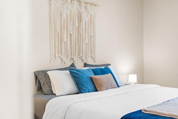 : un lit king size tranquille habillé de blues pastel doux et de blancs.