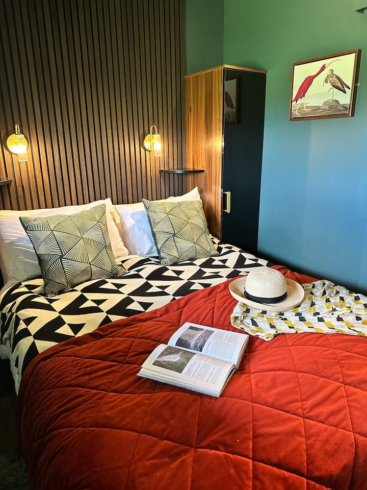 Naša druhá spálňa má pohodlnú manželskú posteľ s tenkými skrinkami na oboch stranách na pohodlné odkladanie. Užite si pokojnú noc na kvalitnom matraci s profesionálne vyčistenou bielou bavlnenou posteľnou bielizňou. 