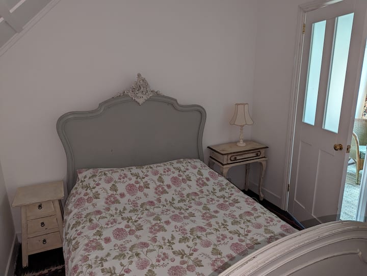 Bedroom 2 with French antique double bed and bedside cabinets. Accessed via a vestibule which also leads to the other bedroom. There is an internal window to this room and a glazed door.