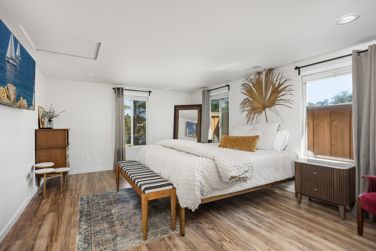 Chambre principale moderne bohème avec lit King Size Cal, rideaux occultants et grand placard double. 