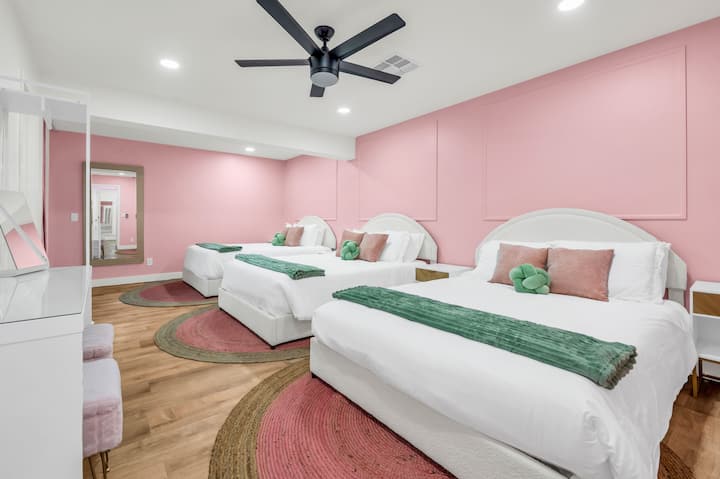Bedroom 1 is an oversized room that includes 3 queen beds, each with their own storage and plenty of charging ports as well as a private bathroom and direct access to the backyard/pool!