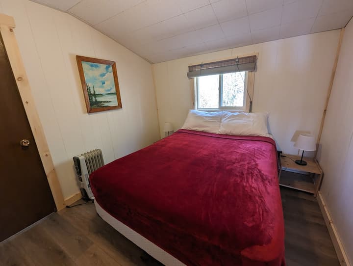 Commencez votre journée dans cette chambre principale accueillante, avec un lit queen size et une fenêtre qui apporte une lumière naturelle du matin.
