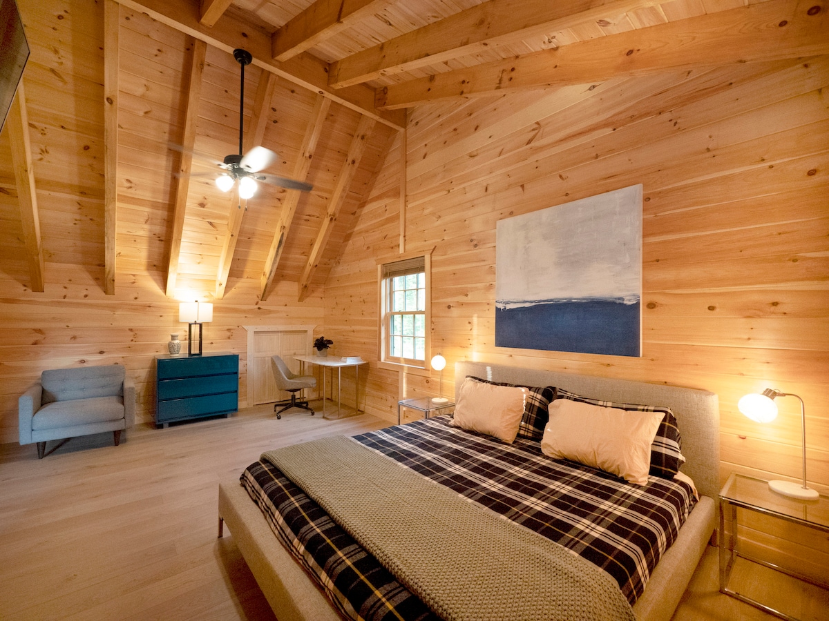 The master bedroom upstairs is very spacious and features vaulted ceilings, an en suite bathroom, a king bed and a desk for computer work along with ample floor space for doing yoga. It also includes the only other television in the house.