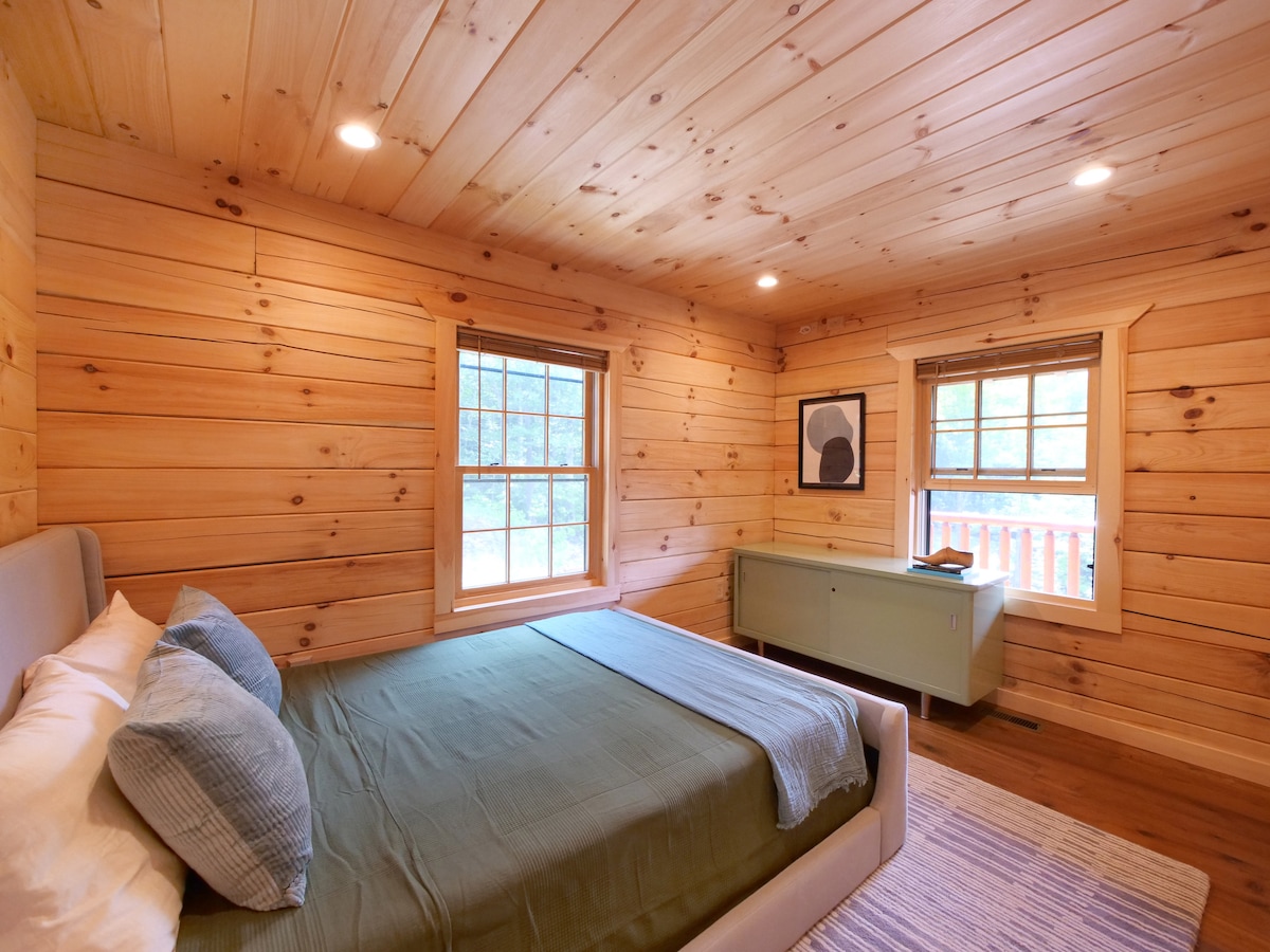 The queen bedroom downstairs features a pistachio green refurbished mid-century credenza full of old wooden toys and board games. 