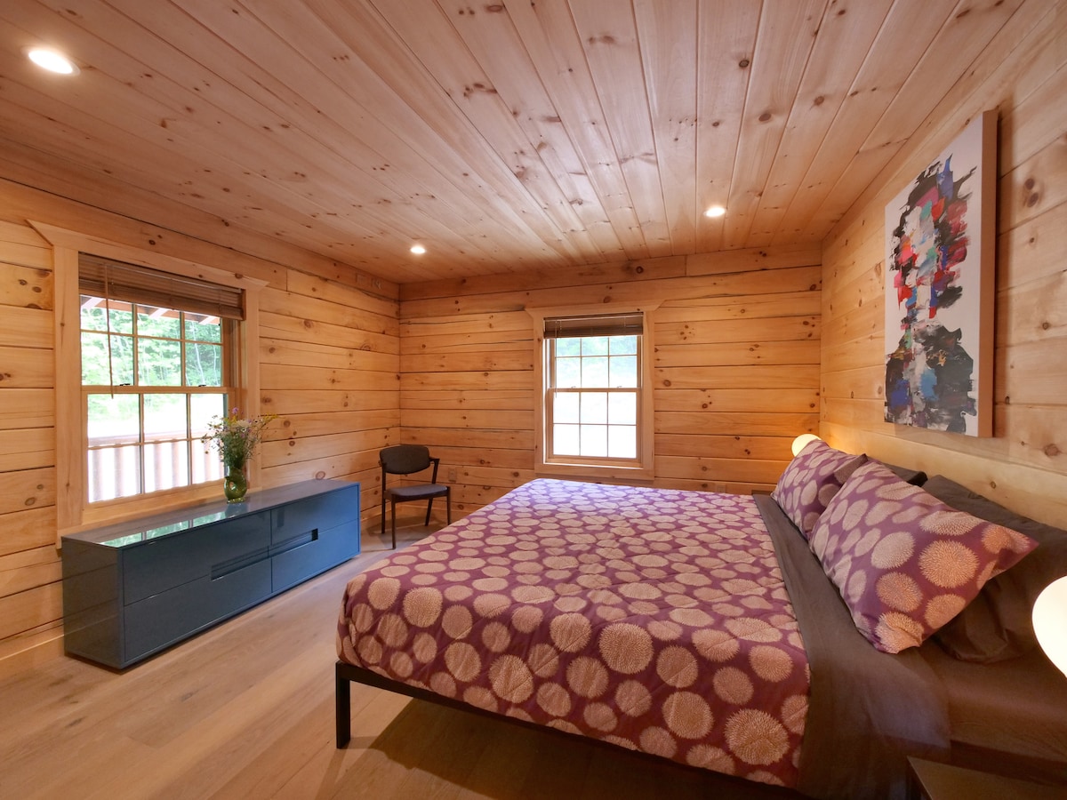 The king bedroom downstairs features a low, wide lacquered dresser, a full closet, views of the hillside and our favorite piece of artwork in the entire house. 