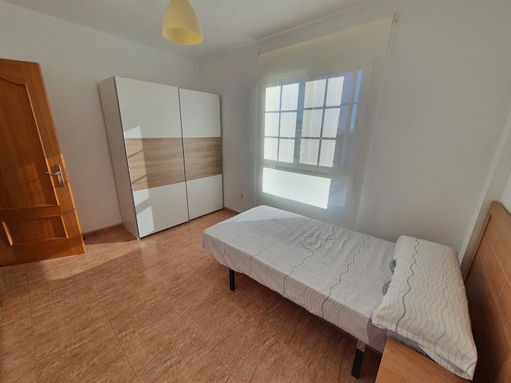Dormitorio con ventana al exterior, hacia la zona de la piscina comunitaria. Cama de 105 con armario. Es contiguo al comedor y tiene un pequeño pasillo con un baño completo y el dormitorio 3.