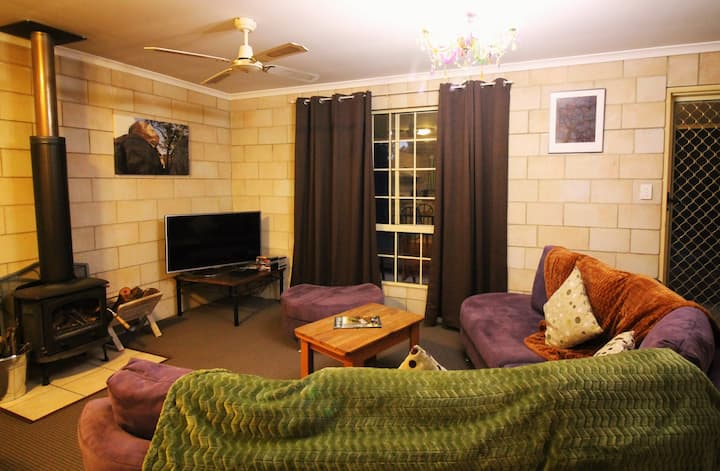 อบอุ่นกับครอบครัวบนโซฟาขนาดใหญ่หน้าทีวีและเตาผิงในร่มที่อบอุ่น