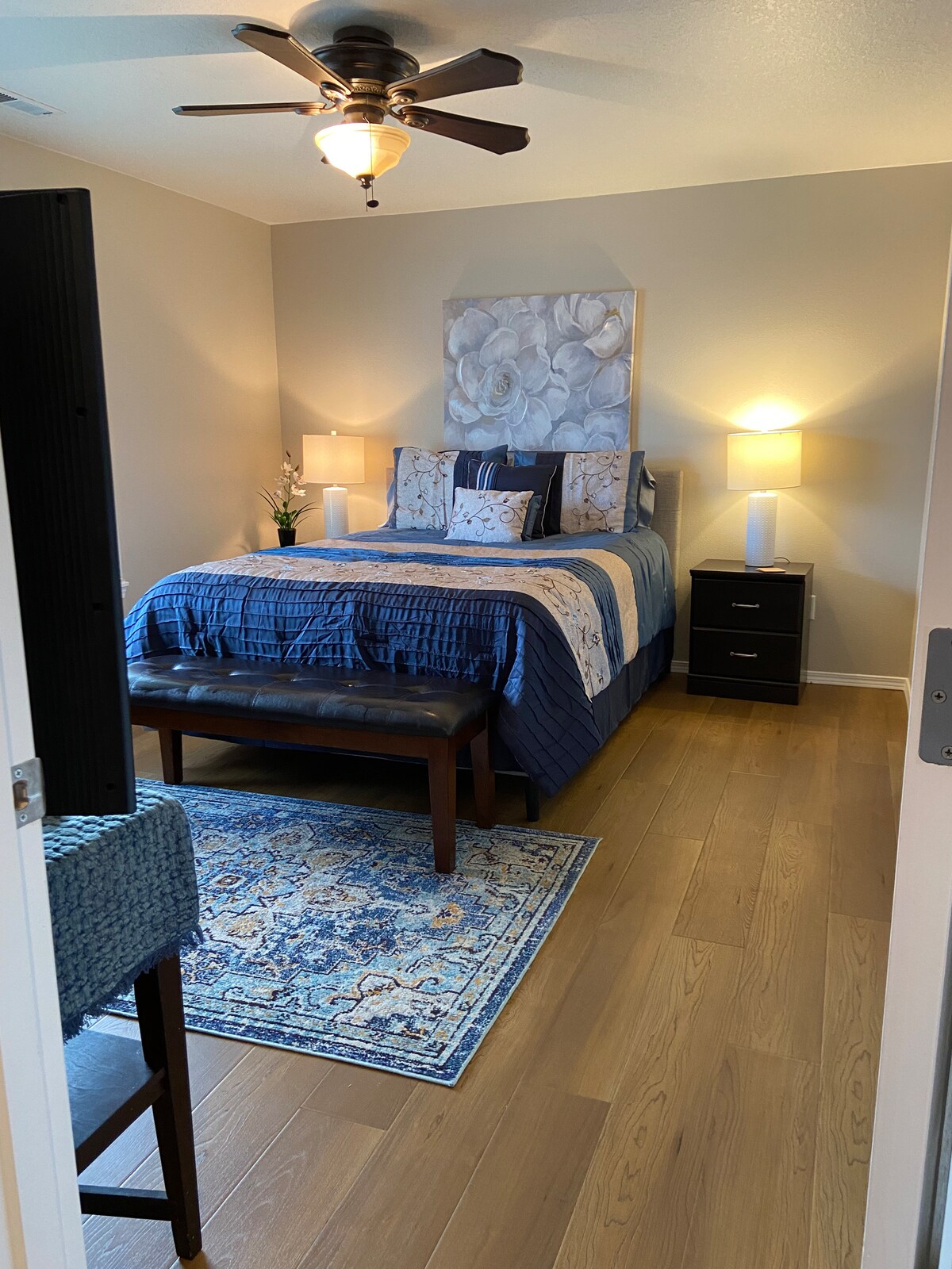 Dormitorio principal espacioso y bellamente decorado con baño privado con cama queen y televisor inteligente.