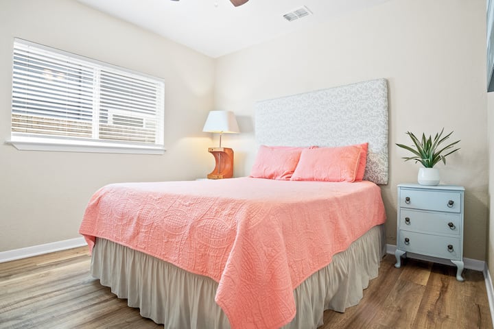 Serene guest bedroom with a cozy queen bed and minimalist beach décor. Soft coastal accents and airy tones create a calm retreat for guests to rest and recharge.