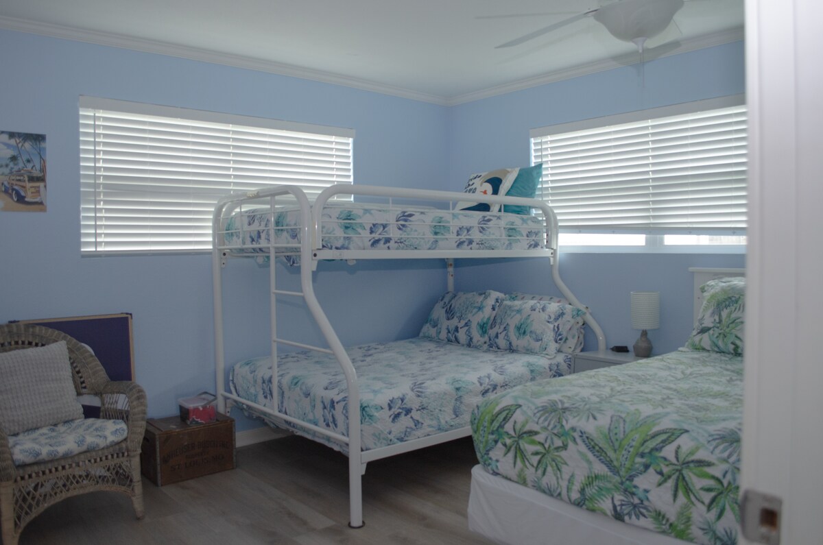 次卧配有全尺寸床和双人床，上下铺和电视 