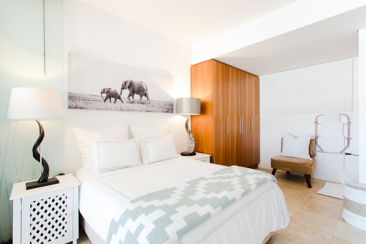 Een queensize bed en een glazen douche en eigen toilet en wastafel plus ingebouwde kasten.