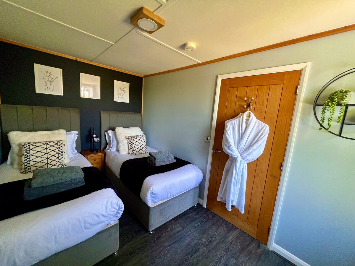 Twin bedroom, with smart tv, towels and dressing gowns provided for each guest.