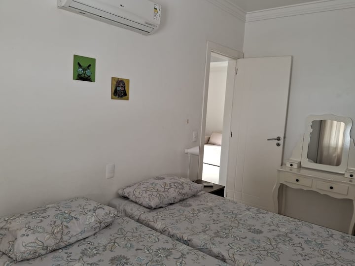 Dormitorio compartido con 2 camas individuales, aire acondicionado dividido y armario.