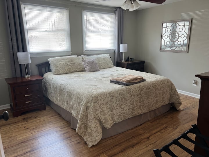 Dormitorio principal fuera de la cocina. Cama tamaño king con sábanas, cómoda para guardar tu ropa. Baño privado con combinación de bañera/ducha. Se proporcionan toallas y papel higiénico. Por favor, trae tus propios artículos de tocador como jabón, champú o acondicionador. 