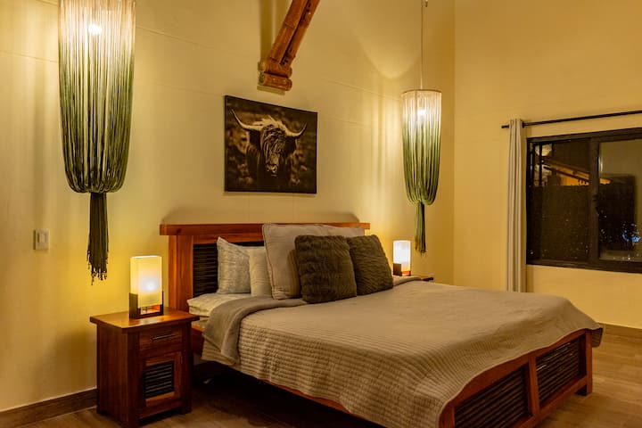 Master bedroom with king bed, extra double bed, private bathroom, walk-in closet, full-body mirror, hair dryer, and cozy linens. Ideal for families or groups looking for comfort and relaxation in a spacious, well-equipped retreat.