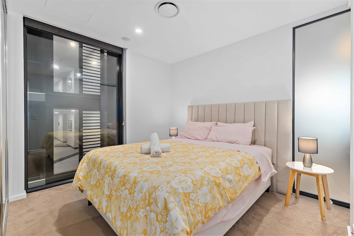 Naša spálňa ponúka pokojné útočisko. Pohodlná posteľ zdobená mäkkou posteľnou bielizňou je doplnená štýlovým čelom postele a okolitým osvetlením pre pokojný pobyt.