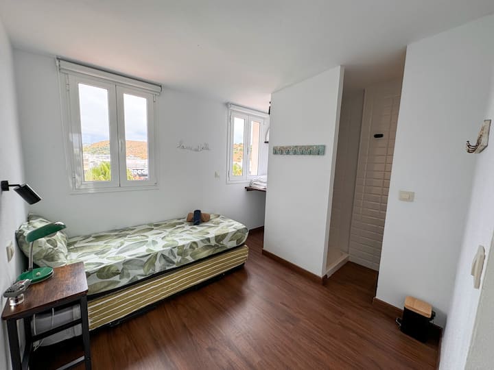 Spavaća soba na katu. Ima krevet od 90 cm, noćni ormarić s retro svjetiljkom i pribor za čitanje te malu policu/ radni stol. Soba ima WC školjku i tuš-kabinu. Orientación al Este.