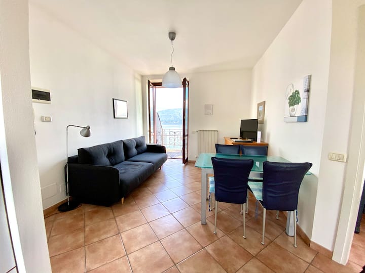 Obývacia izba a jedáleň s rozkladacou pohovkou, televízorom a výhľadom na jazero. 