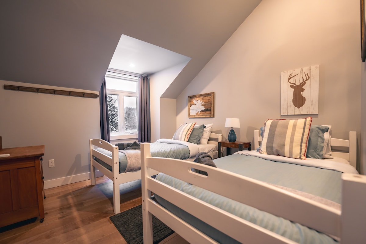 Მეორე სართულზე მე-3 საძინებელში არის ორი ტყუპი საწოლი, გვერდითი მაგიდა, ლამპა, უჯრის გულმკერდი და წითელი მდინარის ხედი.