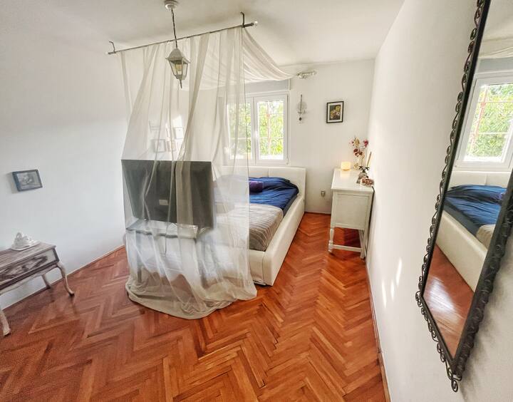Main bedroom with baldachin bed and TV.