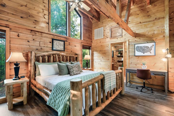 The loft features a comfortable king bed for restful nights, complemented by a functional work desk and chair offering the perfect space to catch up on work with a view of the surrounding nature