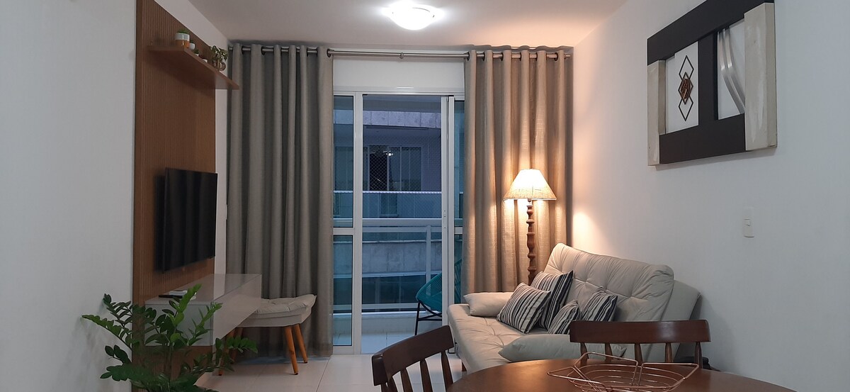 Sala de TV con mesa de comedor. En el fondo, puerta de acceso al balcón.