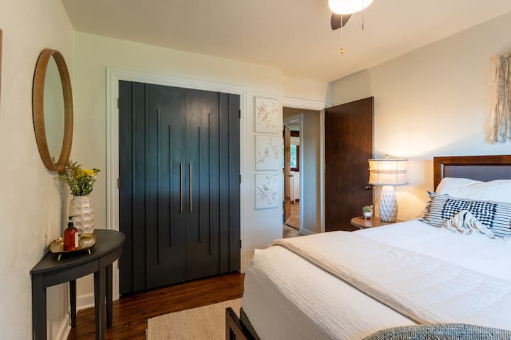 Тази спокойна спалня с двойно легло разполага с наскоро завършени дървени подове, достатъчно пространство в гардероба и подредени възглавници и одеяла за нотка на лукс.