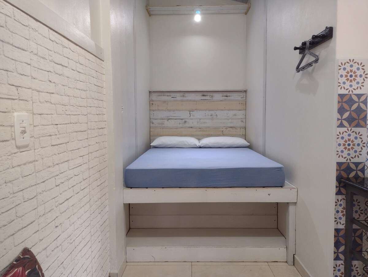 Tweepersoonsbed met schuimmatras en ruimte om kleding aan te trekken. Muurrek.