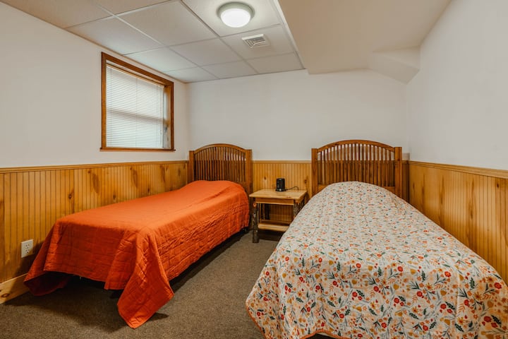 חדר שינה שני במרתף עם שתי מיטות יחיד.
