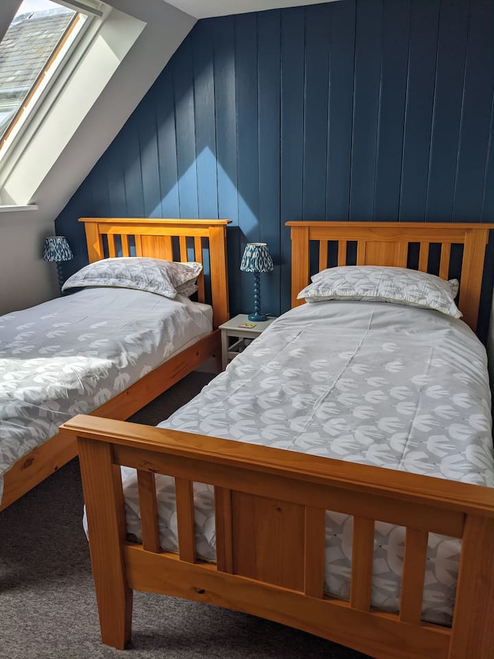 Спалня с две единични легла, обърната на юг. Прозорците имат затъмняващи щори.