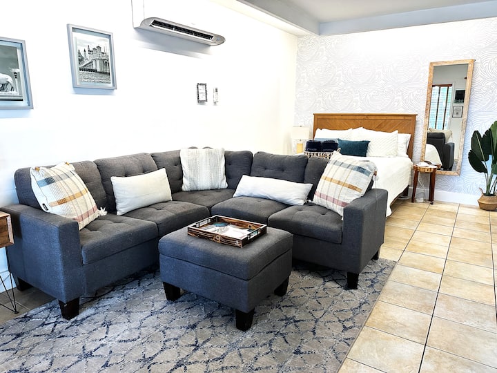 L-shaped couch perfect for relaxing after a day of exploring St. Augustine!  Downstairs queen bed in the background.