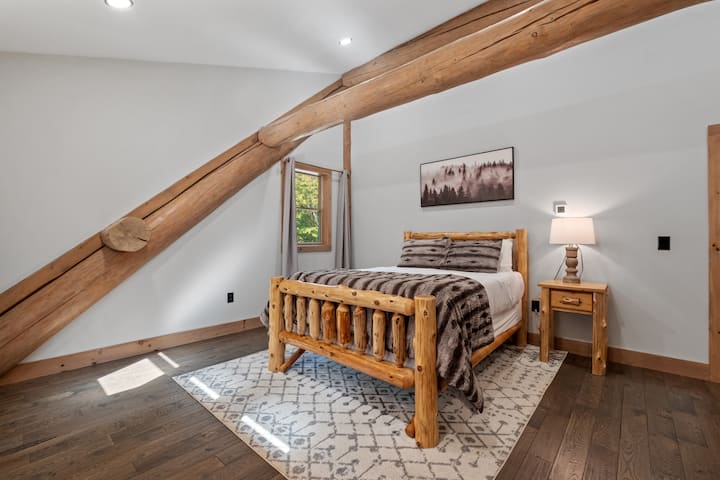 One of two 2nd floor queen bedrooms appointed with black out curtains that will appeal to those with young kids promising a peaceful night's sleep in a cozy and inviting space.
