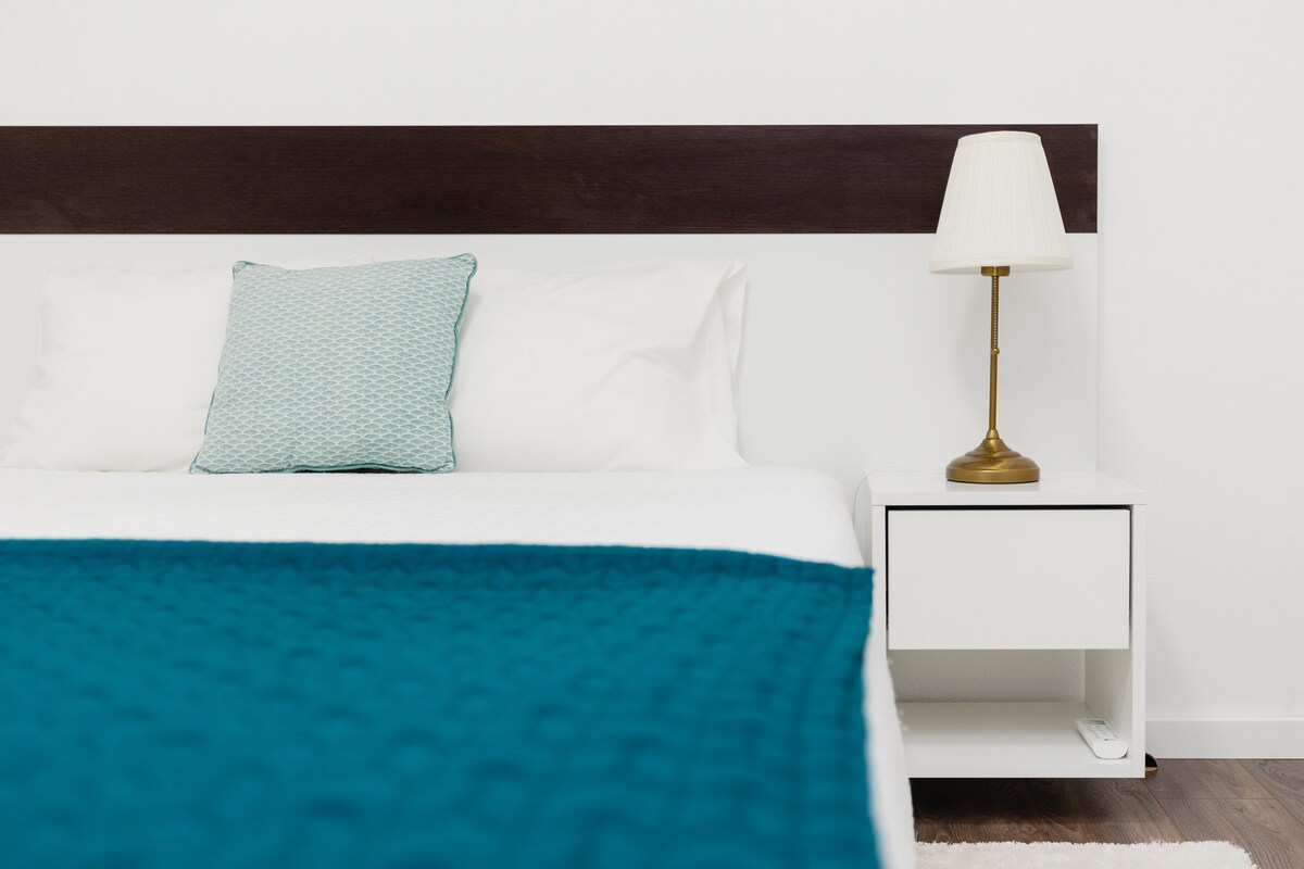 Quarto com vista rio e acesso à varanda.