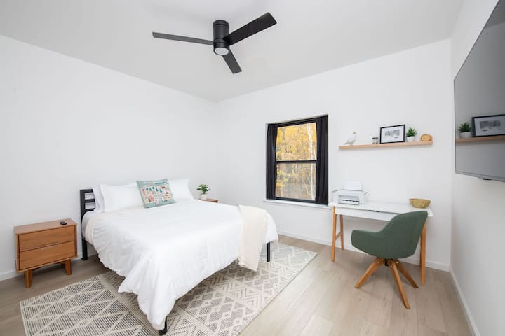 Charming queen bedroom with a private bathroom and workspace for remote working.