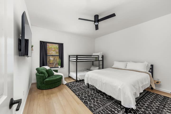 This family suite features a queen bed, twin bunks, and a private bathroom with a soaking tub.