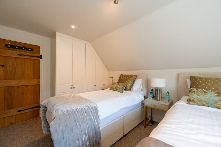 Silid - tulugan sa unang palapag na may dalawang single bed.