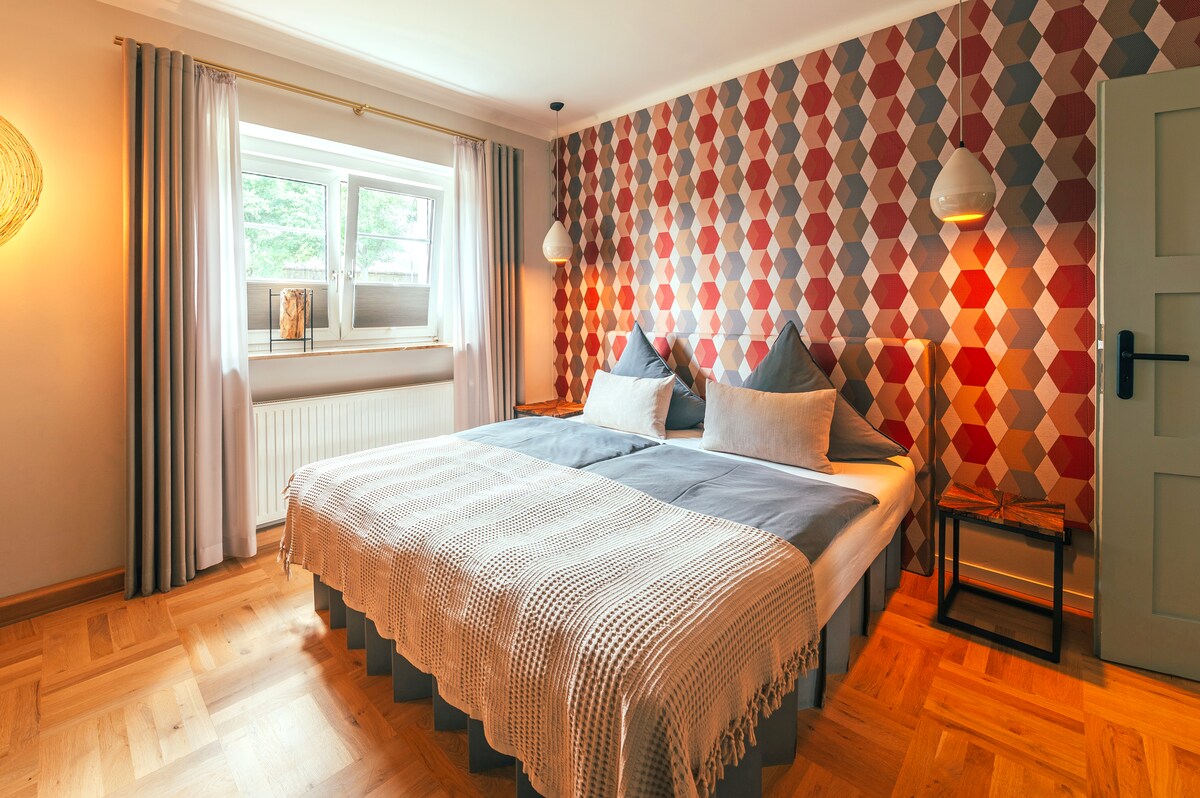 Spálňa s výhľadom, pohodlná manželská posteľ, stmievateľné nočné svetlá, obloženie stien v dizajne 60. rokov pre príjemnú akustiku, 3x ochrana proti oslneniu a svetlu na oknách