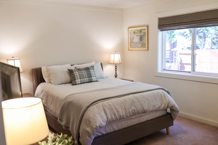 A queen sized bed overlooks the backyard.  This room features a closet with mirrored doors, a large chest of drawers, two bedside tables and a 4K TV.