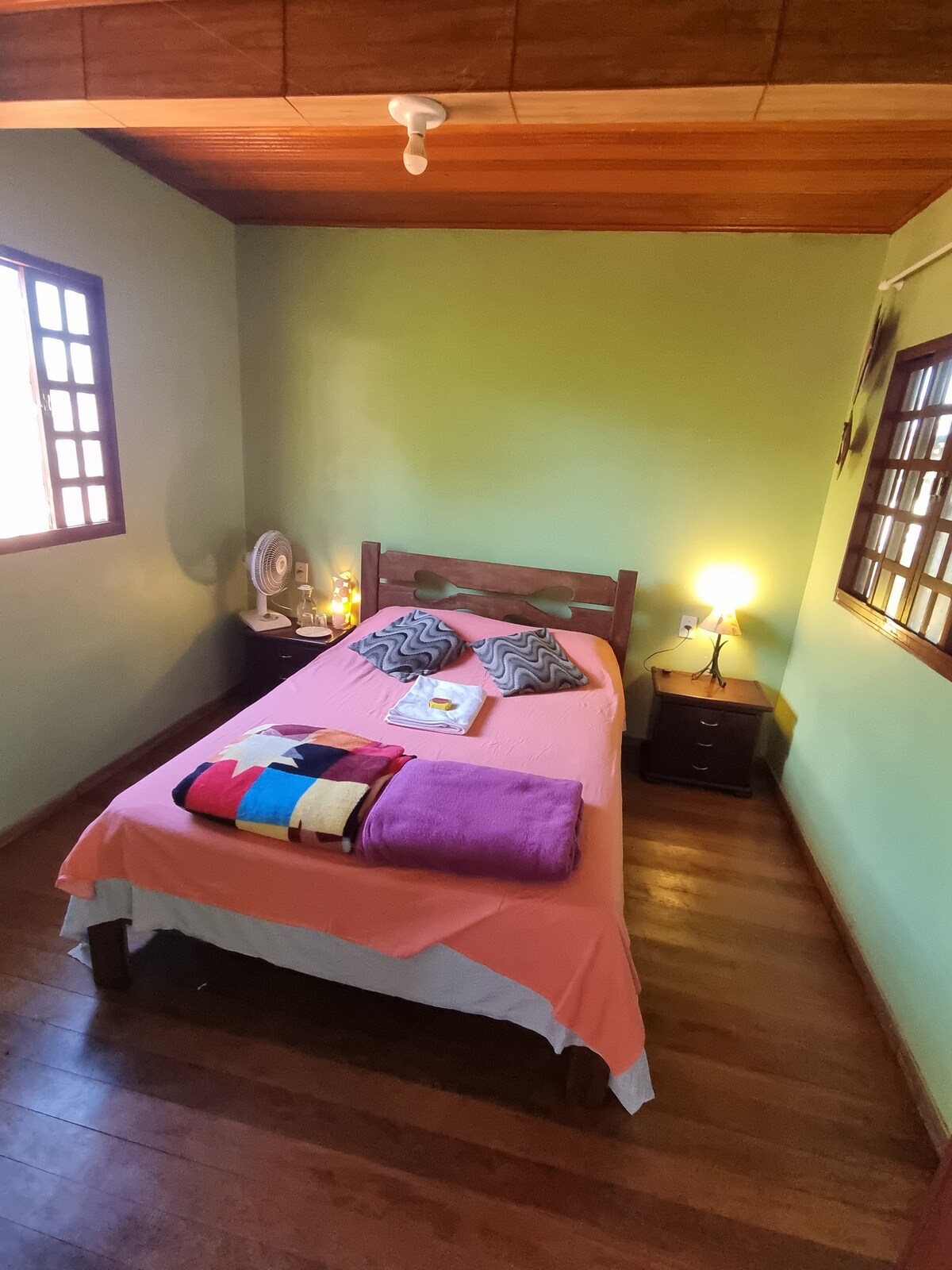 ห้องพักพร้อมเตียงคู่โต๊ะข้างเตียง 2 ตัวผ้าปูที่นอนสะอาดและผ้าปูที่นอนสำหรับอาบน้ำและพัดลม