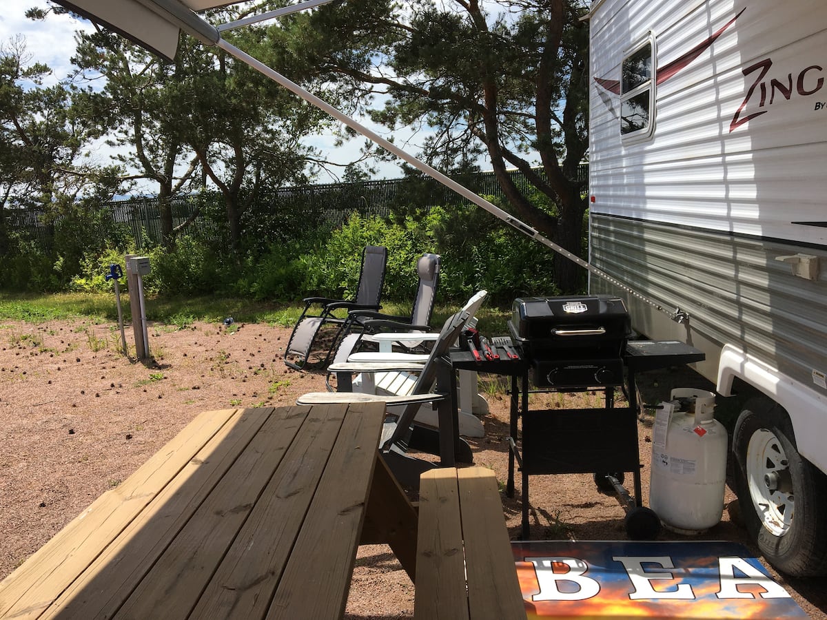 Wooden entry deck with BBQ beside the camper