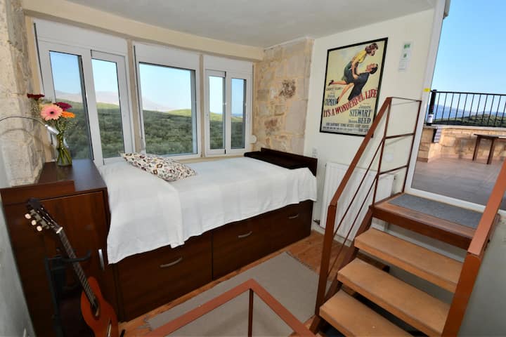 Гнездото на грифона в главната къща.  Студио апартамент с персонализирано легло, вградено в каменния таван, панорамна гледка към полуостров Грамвуса и частен достъп до покривната тераса на основната къща.