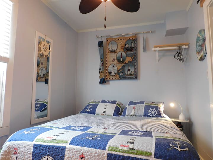 Queen bed with side table and light.