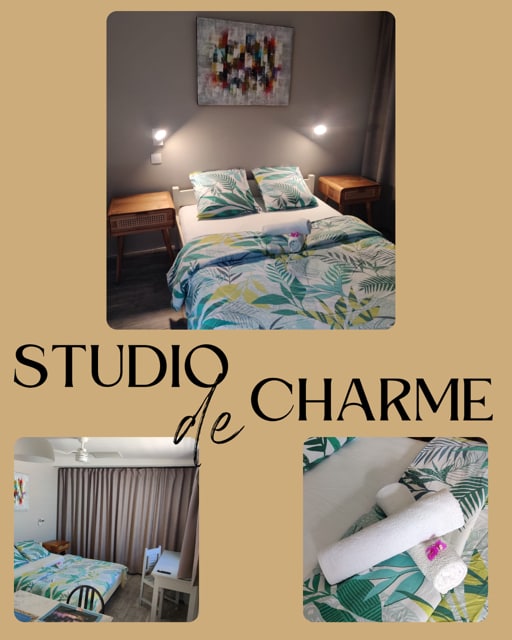 A bright sleeping area features a spacious bed dressed in tropical-patterned bedding. Two bedside tables sit beside the bed with wall-mounted lights above. A colorful wall art piece adds a decorative touch to the neutral wall. A corner workspace with a chair is also visible.