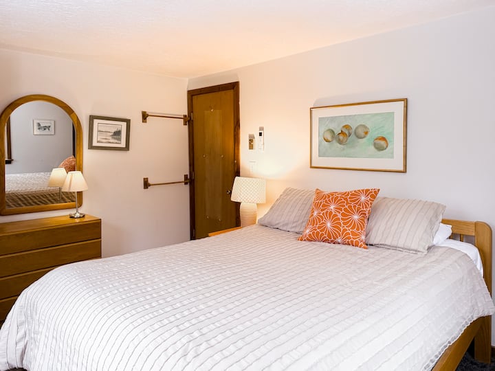 Chambre lumineuse et confortable aux tons neutres doux et à l'éclairage chaleureux
